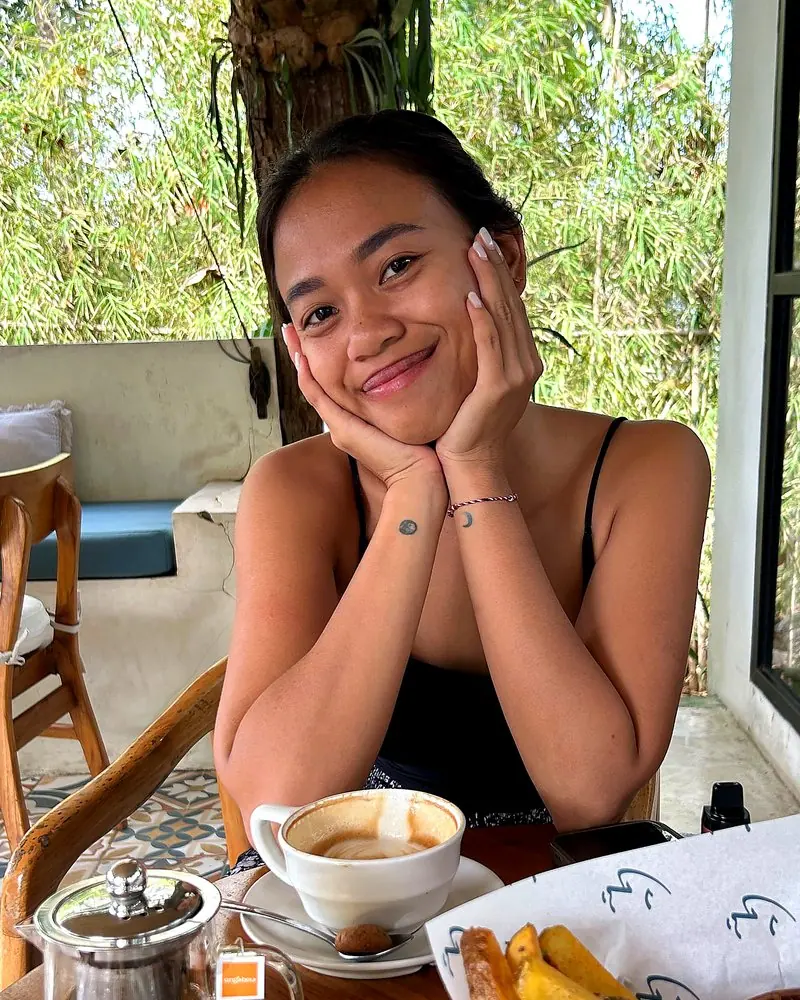 Aina, founder of Color Me Happy, smiling at a café table