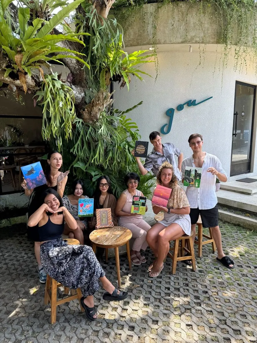 Group photo of guests holding their canvases outside the venue